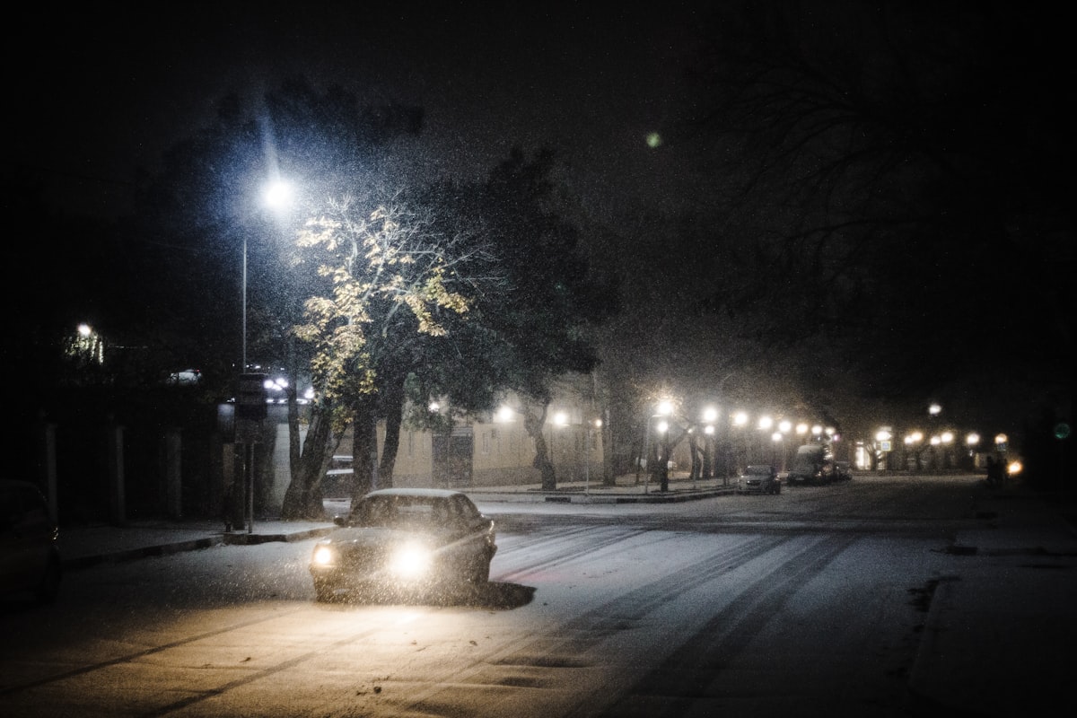 夜の雪道とヘッドライトの車