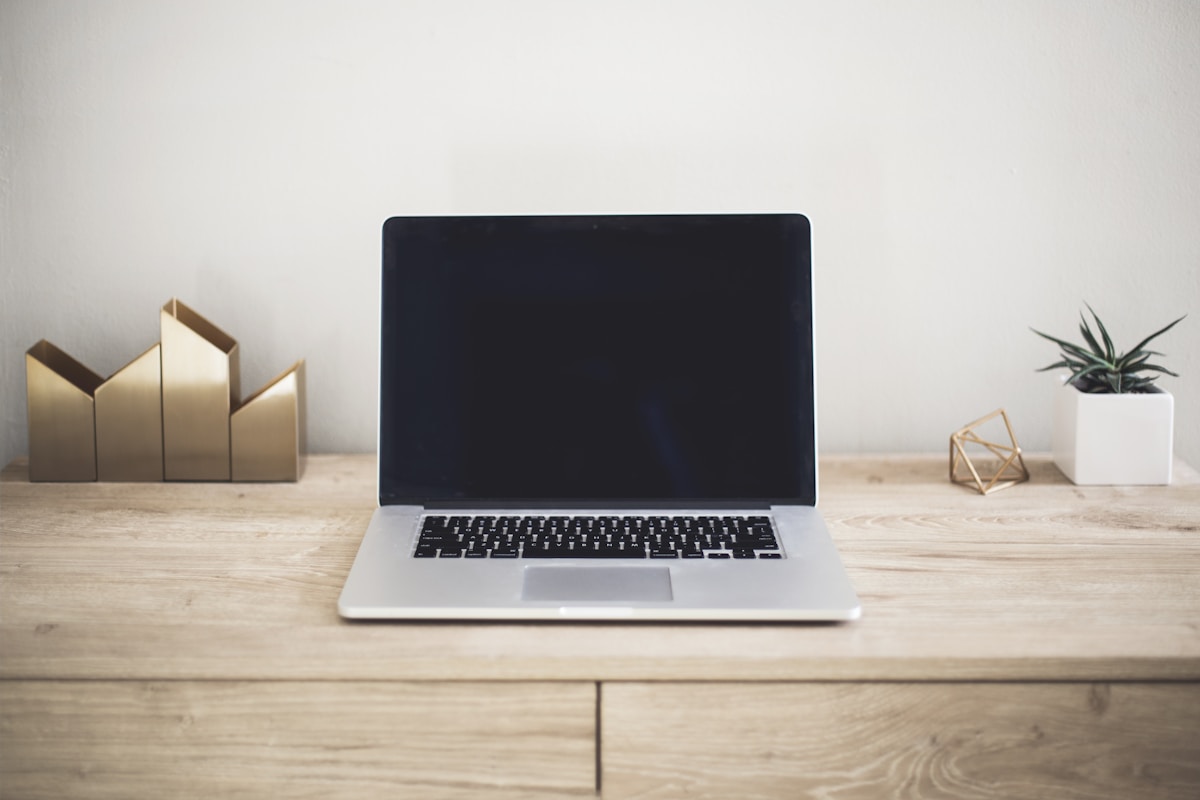 木の机の上のMacBookとノート・夫婦でブログを書いている朝