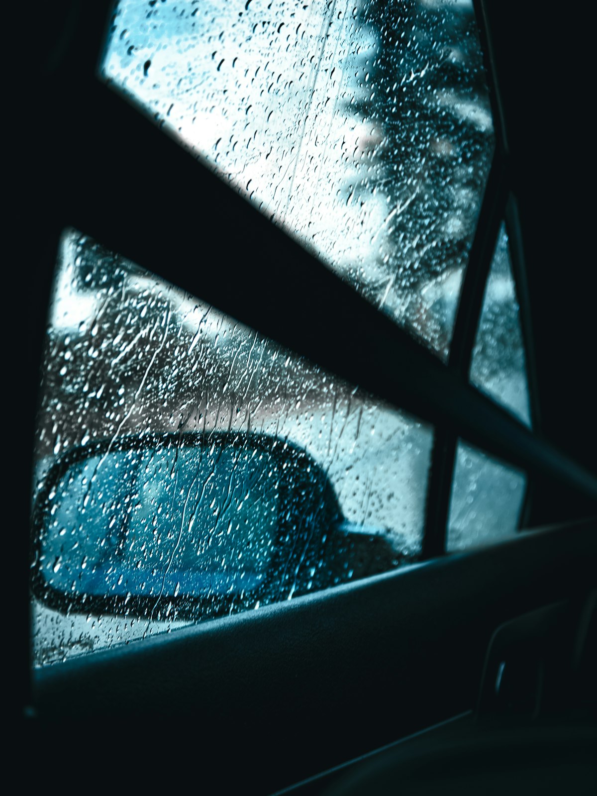 雨の車窓越しに見るサイドミラー・振り返る視線