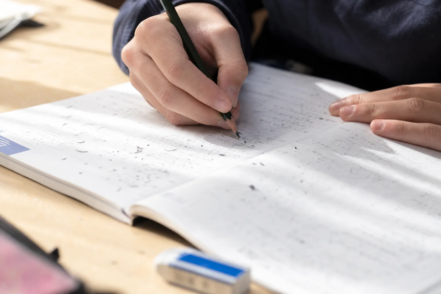 何度も消して解き直した問題集に鉛筆で書き込む手元