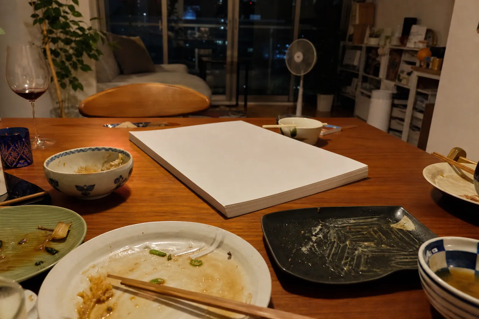 食べかけの夕食の横に、伏せて置かれたA3の紙の束