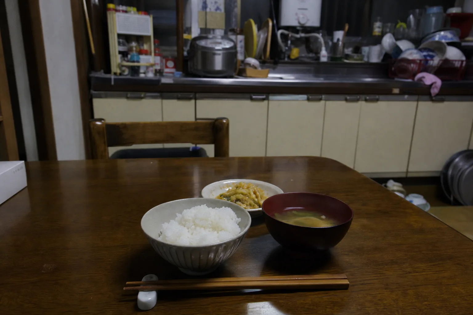 実家の食卓、湯気の立つご飯と味噌汁が一人分