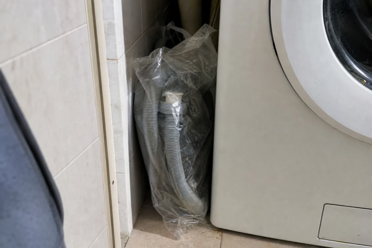 洗濯機の脇に、袋に入ったまま未開封の風呂水ホース
